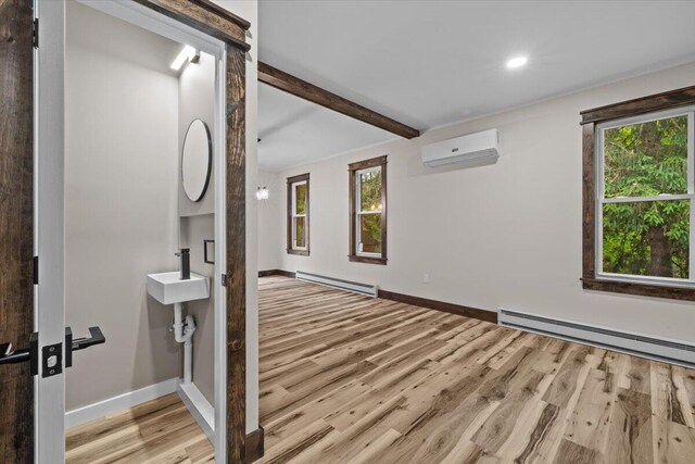 15 Locust Ridge Rd, Thornhurst, PA 18424 - empty room featuring a wall mounted AC, a baseboard heating unit, wood finished floors, beamed ceiling, and baseboard heating