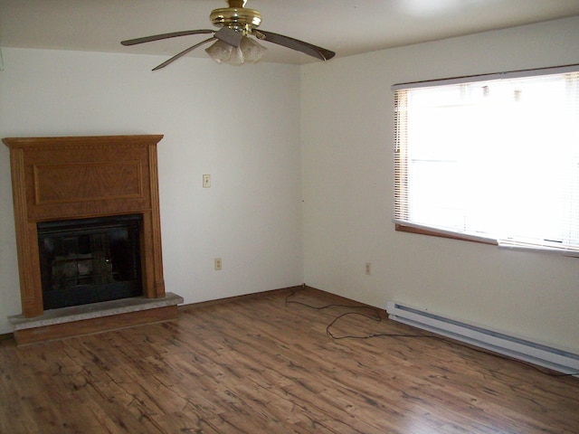 1166 Hunters Woods Dr, East Stroudsburg, PA 18301 - unfurnished living room featuring a baseboard radiator, wood finished floors, ceiling fan, and a fireplace with raised hearth