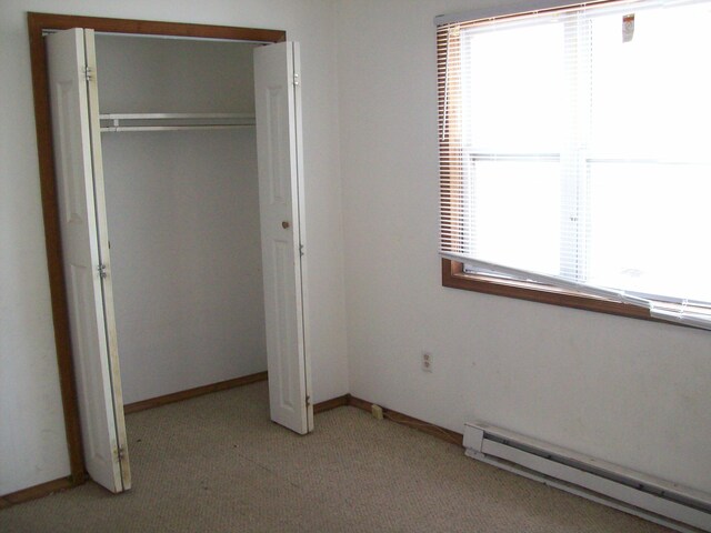 1166 Hunters Woods Dr, East Stroudsburg, PA 18301 - unfurnished bedroom featuring baseboard heating, a closet, light colored carpet, and baseboards