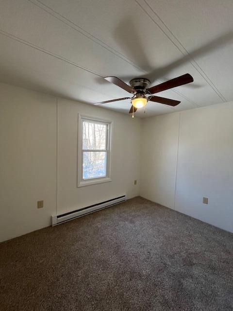 carpeted spare room with a ceiling fan and a baseboard radiator