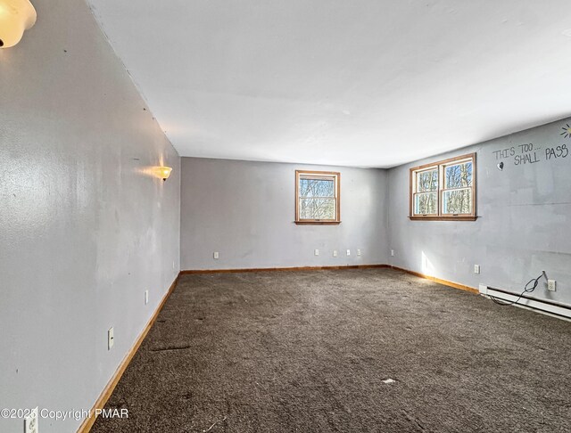 spare room featuring carpet floors, a baseboard radiator, and baseboards