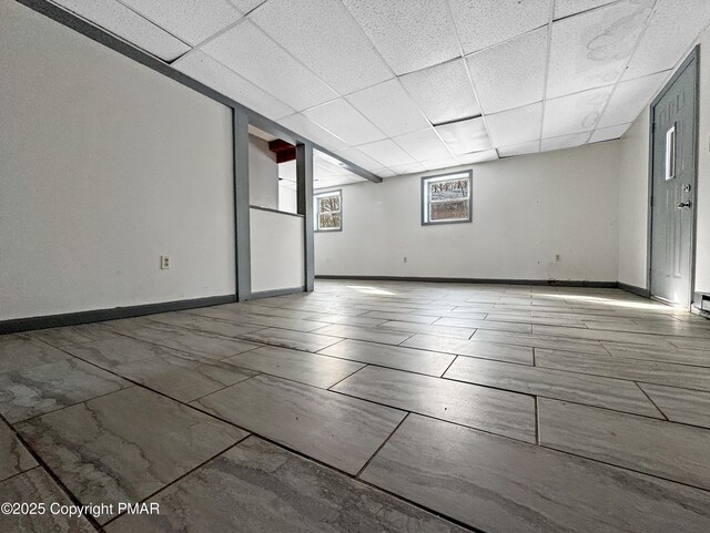 spare room with a drop ceiling and baseboards