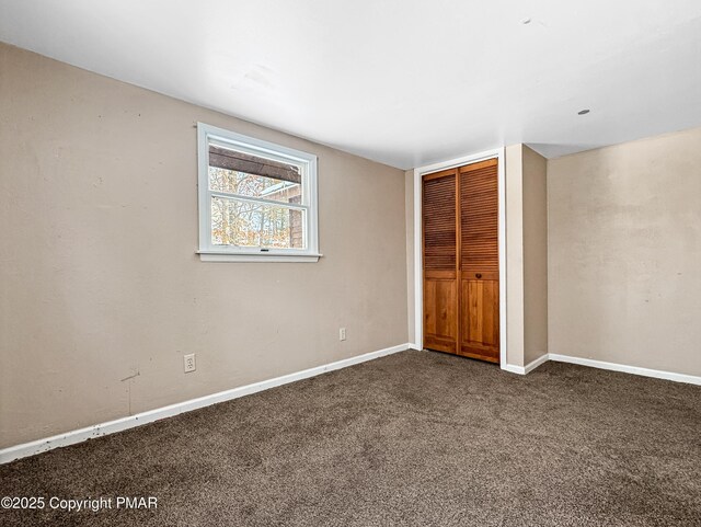 unfurnished bedroom with carpet floors, baseboards, and a closet