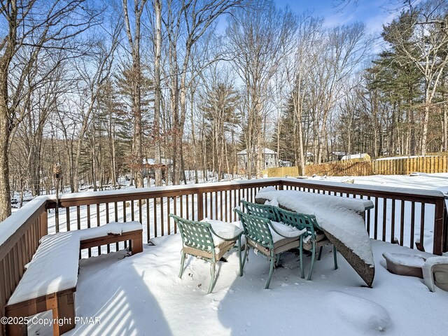 snow covered deck featuring fence