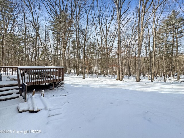 yard covered in snow featuring a wooden deck