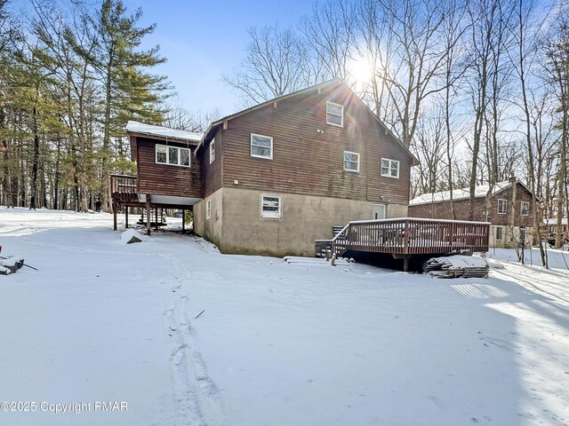 snow covered property with a wooden deck