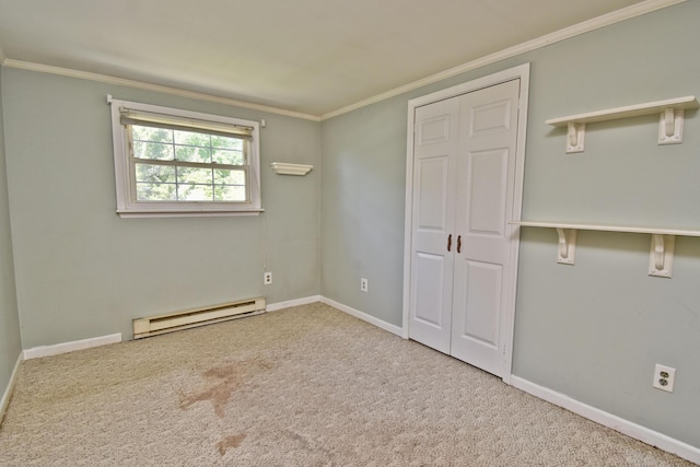 unfurnished bedroom featuring a baseboard heating unit, ornamental molding, carpet flooring, baseboards, and a closet