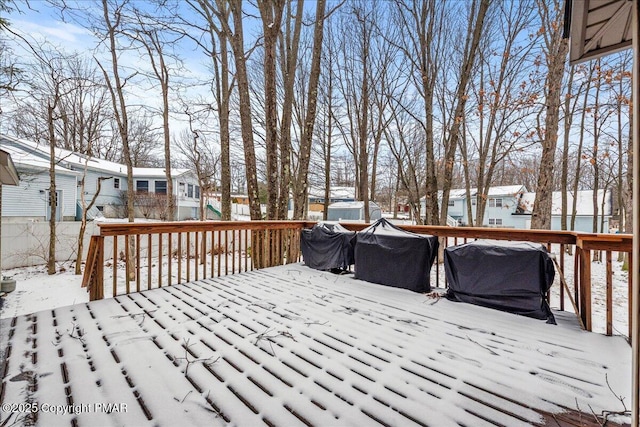 snow covered deck featuring a residential view and fence