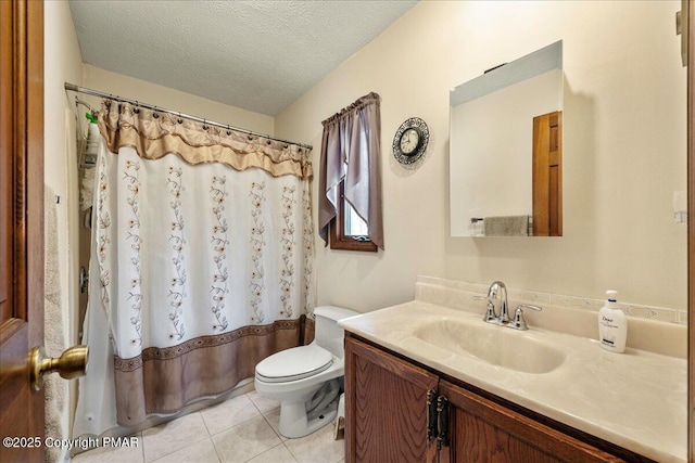 full bathroom featuring a shower with shower curtain, toilet, tile patterned floors, a textured ceiling, and vanity