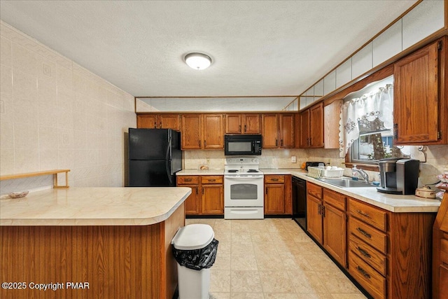 kitchen featuring black appliances, brown cabinetry, a sink, and light countertops