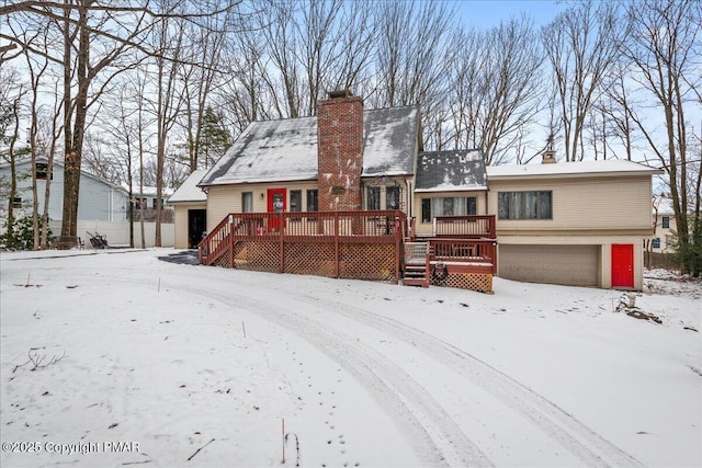 view of front of house featuring a garage, a deck, and a chimney