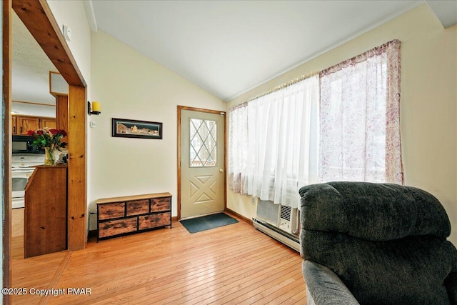 interior space featuring a baseboard heating unit, wood-type flooring, and lofted ceiling