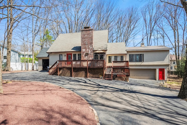 6 Cobblewood Dr, Mount Pocono, PA 18344 - view of front of home featuring a wooden deck, a garage, a chimney, and asphalt driveway