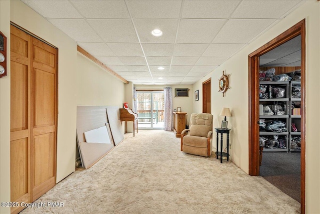 sitting room with a paneled ceiling, carpet flooring, a wall unit AC, and recessed lighting