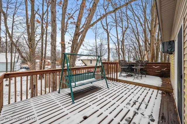 snow covered deck featuring outdoor dining space