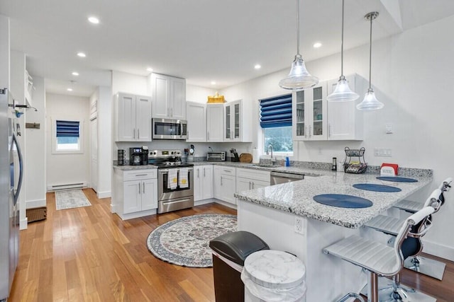 22 Petrarch Trl, Albrightsville, PA 18210 - kitchen featuring a peninsula, a breakfast bar, appliances with stainless steel finishes, a sink, and a baseboard radiator