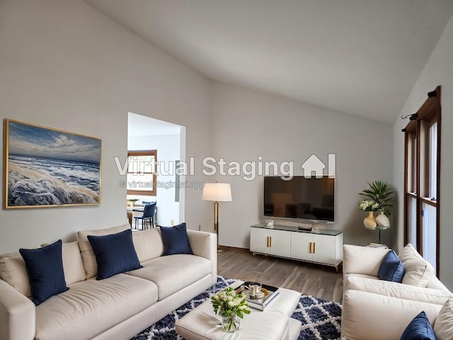 living room with wood finished floors and vaulted ceiling