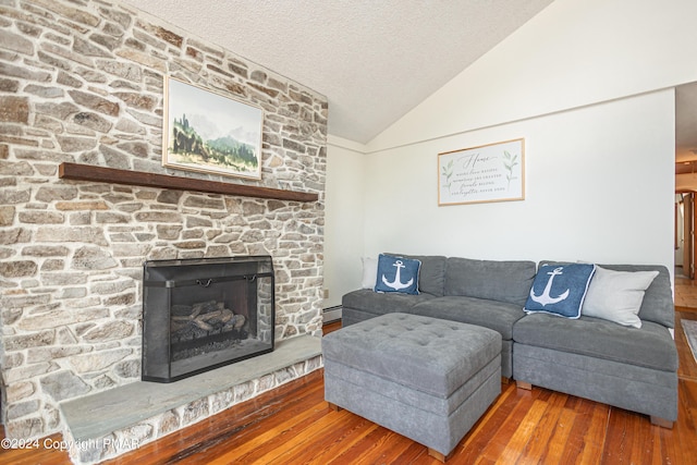 151 S Lake Dr, Lake Harmony, PA 18624 - living room featuring a baseboard radiator, wood finished floors, vaulted ceiling, a textured ceiling, and a fireplace