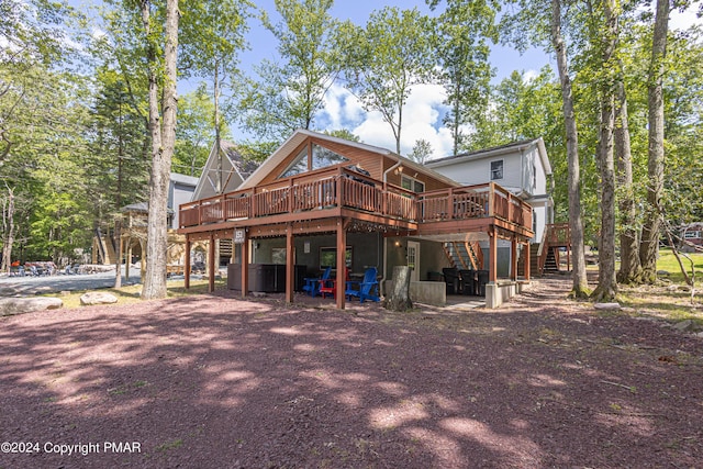 rear view of property featuring stairway and a wooden deck