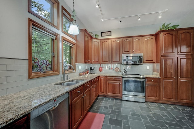 210 Egret Way E, Stroudsburg, PA 18302 - kitchen featuring appliances with stainless steel finishes, a sink, light stone counters, hanging light fixtures, and decorative backsplash