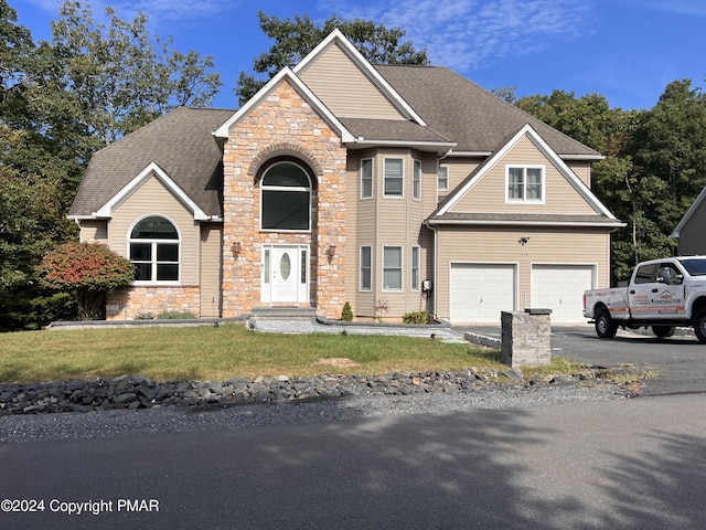 view of front of home with a garage, a shingled roof, driveway, stone siding, and a front yard