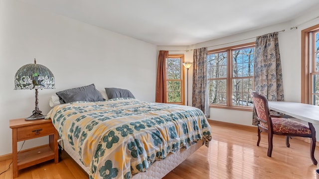 bedroom with light wood-style floors and baseboards