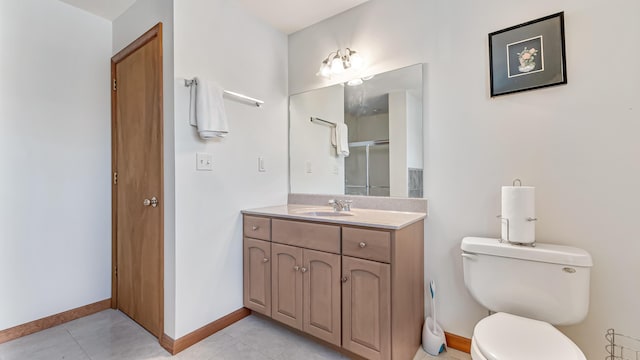 full bathroom with toilet, vanity, baseboards, a shower stall, and tile patterned floors