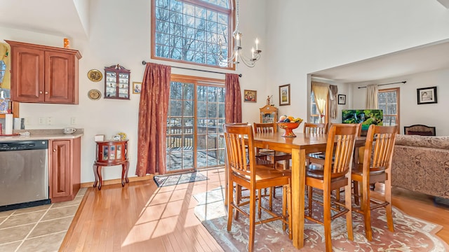 dining room featuring a chandelier, a high ceiling, and light wood-style flooring