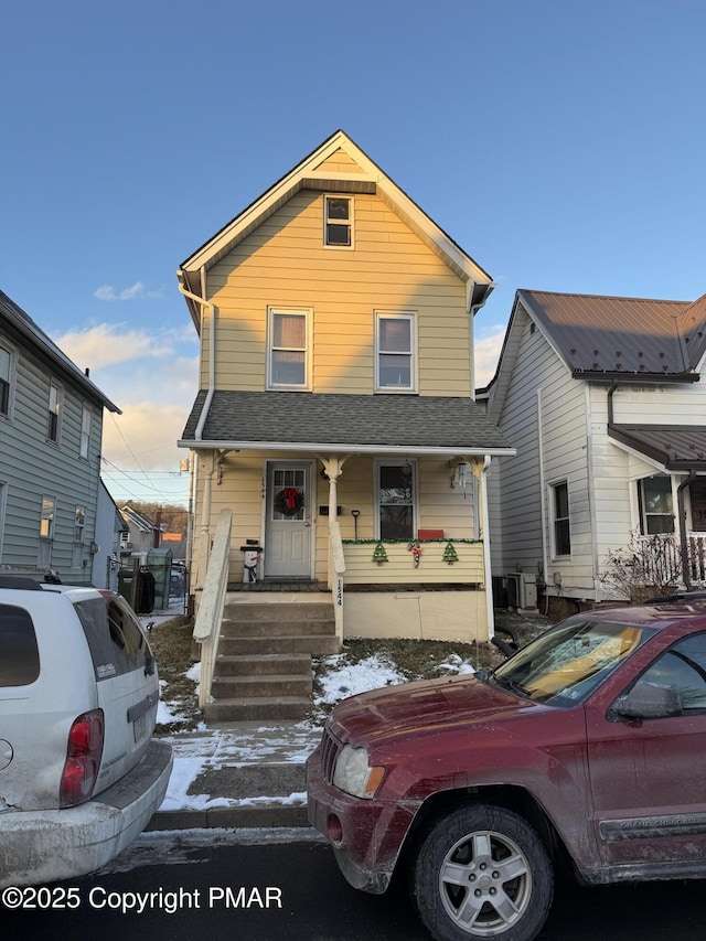 view of front facade featuring covered porch and roof with shingles