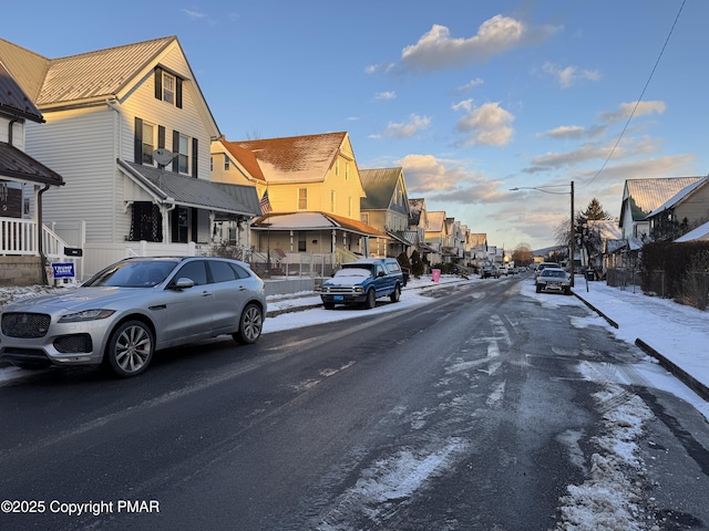 view of road featuring a residential view, street lighting, and sidewalks