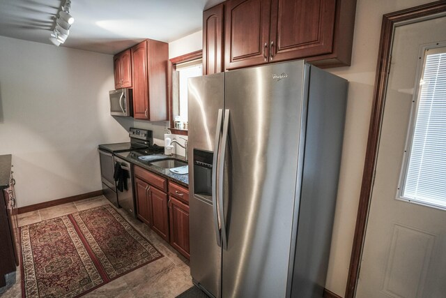 569 Lafayette Ave, Palmerton, PA 18071 - kitchen with appliances with stainless steel finishes, rail lighting, light tile patterned flooring, and dark stone counters