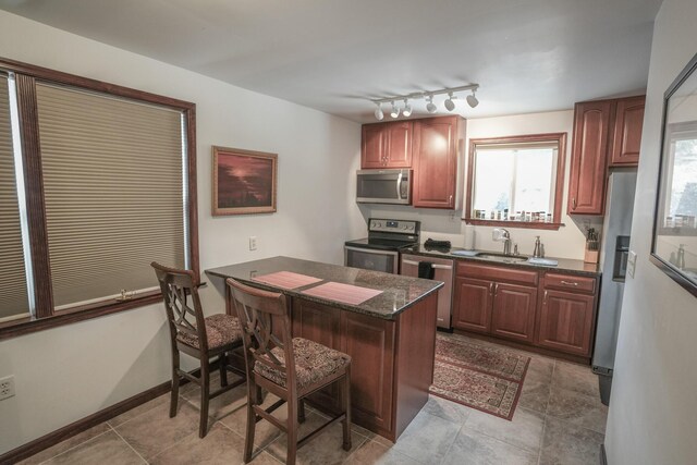 569 Lafayette Ave, Palmerton, PA 18071 - kitchen featuring stainless steel appliances, a breakfast bar area, a peninsula, dark stone counters, and light tile patterned flooring