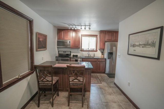 569 Lafayette Ave, Palmerton, PA 18071 - kitchen with appliances with stainless steel finishes, dark countertops, a kitchen bar, a peninsula, and rail lighting
