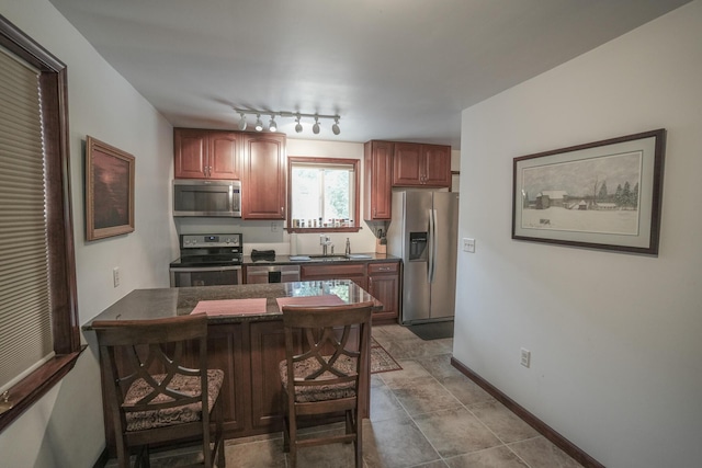 569 Lafayette Ave, Palmerton, PA 18071 - kitchen with stainless steel appliances, dark countertops, a breakfast bar, a peninsula, and rail lighting