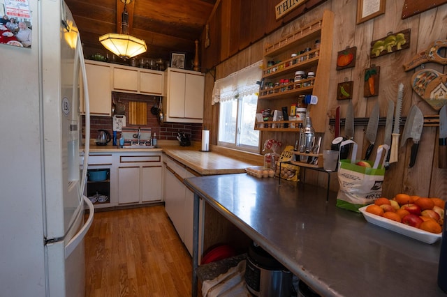 3193 Pine Ridge Dr, Bushkill, PA 18324 - kitchen with a sink, white cabinets, light wood-style flooring, wooden ceiling, and freestanding refrigerator