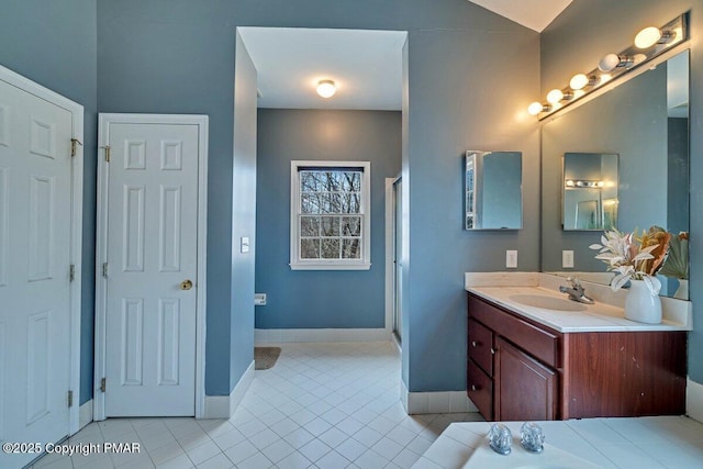 full bathroom with a shower stall, vanity, baseboards, and tile patterned floors