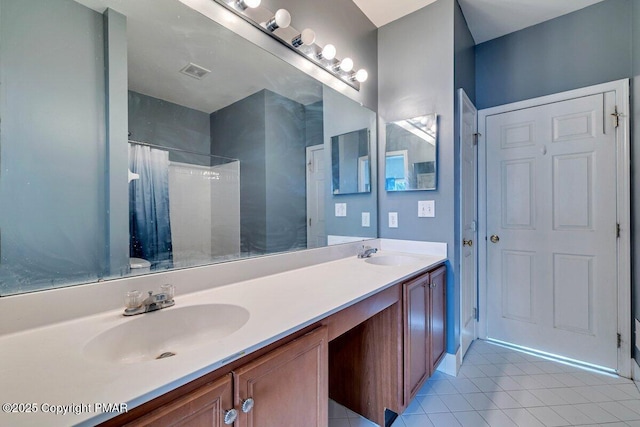 bathroom with double vanity, visible vents, a shower with curtain, tile patterned flooring, and a sink