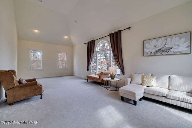 carpeted living area featuring baseboards and high vaulted ceiling