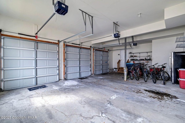 garage with freestanding refrigerator and a garage door opener