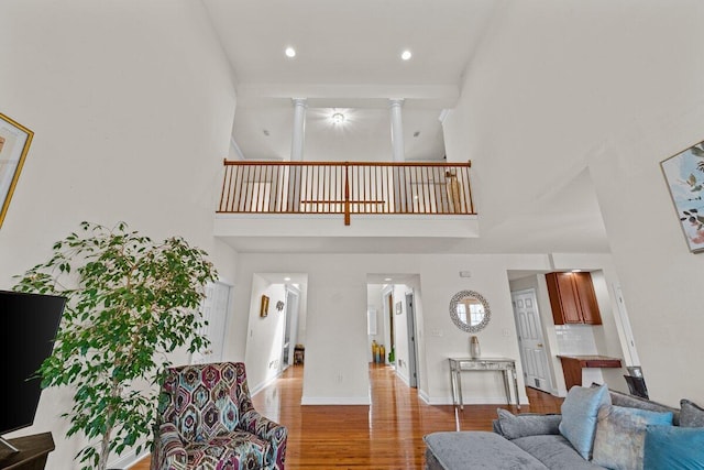 255 Rising Meadow Way E, Stroudsburg, PA 18302 - living room with a towering ceiling, wood finished floors, ornate columns, and recessed lighting