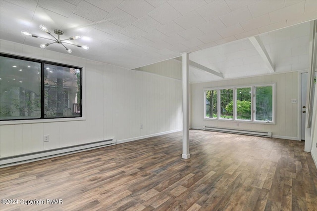 spare room featuring vaulted ceiling with beams, baseboards, baseboard heating, and wood finished floors