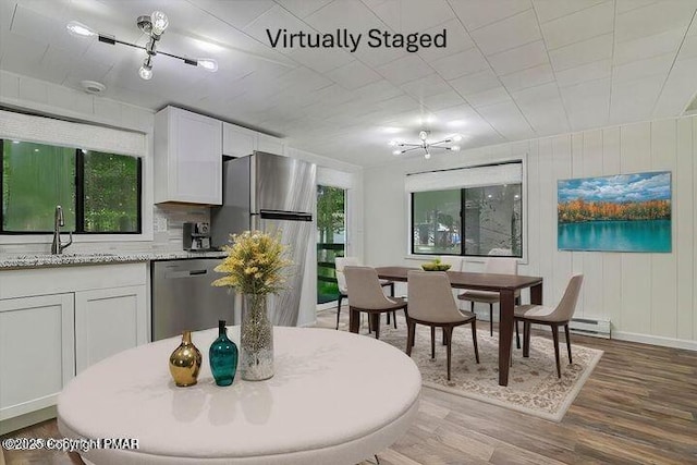 dining space with baseboard heating, dark wood finished floors, and a notable chandelier