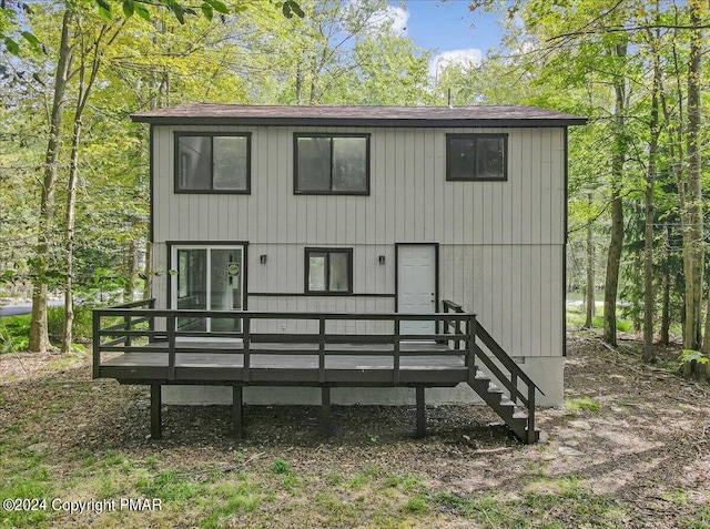 rear view of house featuring a wooden deck