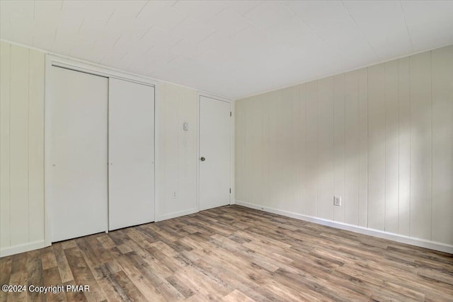 unfurnished bedroom with a closet, baseboards, and wood finished floors