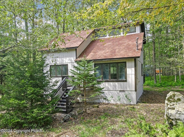 view of front of property with roof with shingles and crawl space