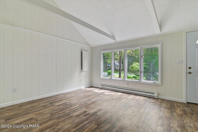 spare room featuring vaulted ceiling with beams, baseboard heating, wood finished floors, and baseboards