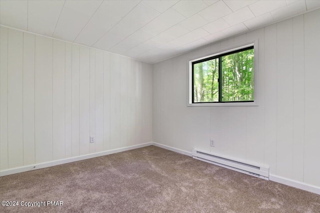 carpeted spare room with a baseboard heating unit and baseboards