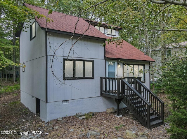 view of front facade featuring crawl space, stairway, and roof with shingles