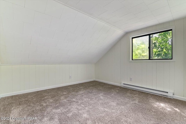 additional living space with a baseboard heating unit, carpet, vaulted ceiling, and baseboards