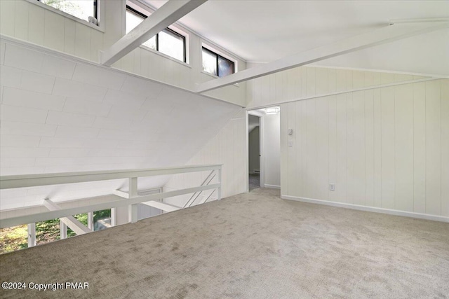 carpeted spare room featuring lofted ceiling with beams and a wealth of natural light